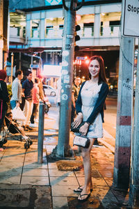 Portrait of woman standing on street in city