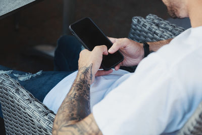 Midsection of man using mobile phone