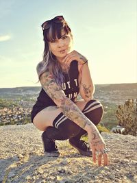 Woman wearing sunglasses on land against sky