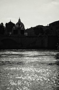 Bridge over river against buildings in city