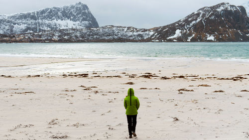 Rear view of man walking at beach