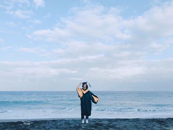 Full length of man standing on sea shore against sky