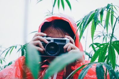 Portrait of woman photographing plant