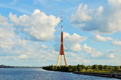 Calm lake with tower against the sky