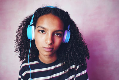 Portrait of beautiful young woman against blue wall