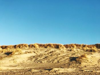 Scenic view of desert against clear blue sky