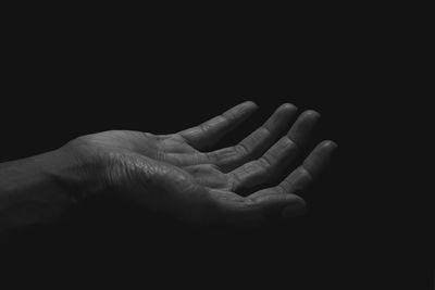 Close-up of hand over black background