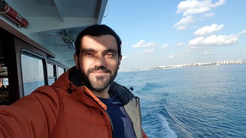 Portrait of man in boat against sky