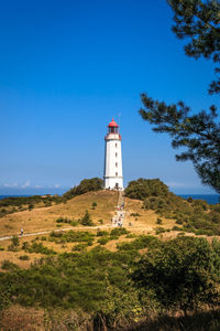 Low angle view of lighthouse by building against sky