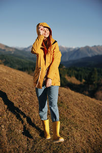 Portrait of young woman standing on mountain