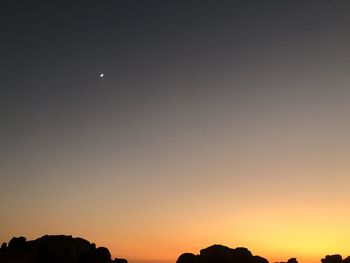 Low angle view of silhouette moon against sky at sunset