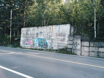 Graffiti on wall by road in city