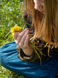 Teenager caucasian girl picking up flowers in springtime in a garden outdoors a sunny day