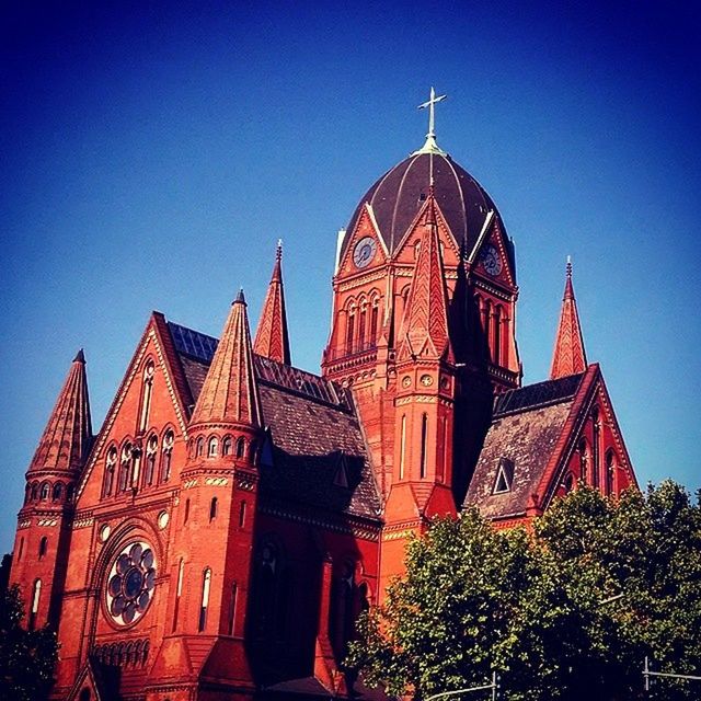 place of worship, religion, building exterior, architecture, spirituality, church, built structure, low angle view, clear sky, blue, cathedral, cross, dome, sky, copy space, outdoors, tree, high section