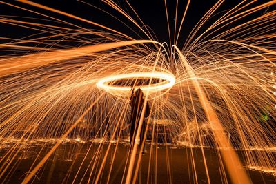 Low angle view of light trails against sky at night