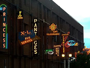 Low angle view of illuminated information sign at night