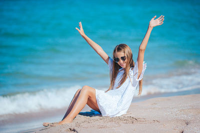 Full length of young woman doing yoga at beach