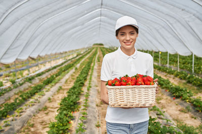 Full length of smiling woman holding basket