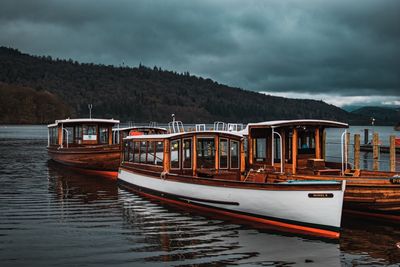 View of boats in sea against cloudy sky