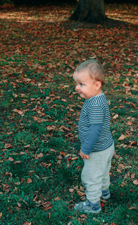 Cute boy standing on ground during autumn