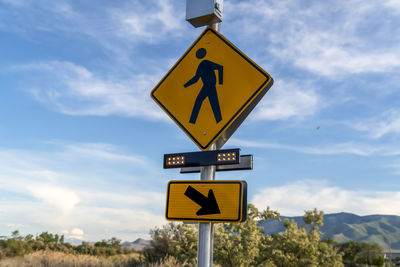 Low angle view of road sign against sky