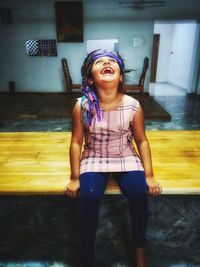 Full length of a smiling young woman sitting on floor