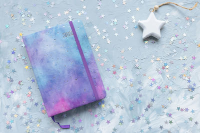 2022 yearly journal, chocolate and stars decoration on desk workspace, blue background. winter