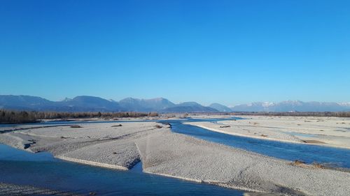 Scenic view of beach against clear blue sky