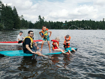 People in boat on lake against sky