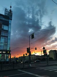 Road sign against sky during sunset