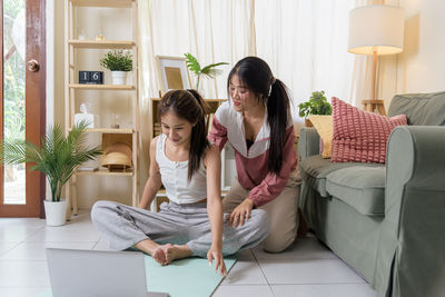 Side view of mother and daughter at home