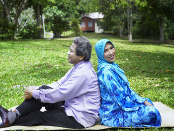 Portrait of smiling woman with man sitting in park