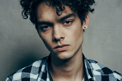 Portrait of young man against wall