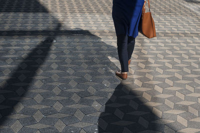 Low section of woman walking on footpath