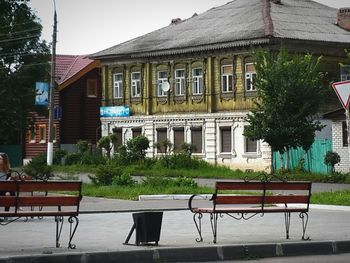 Empty bench in lawn in front of building