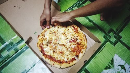 Cropped image of hand holding pizza