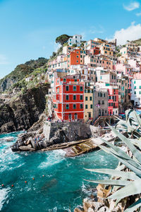 Buildings by sea against sky in city