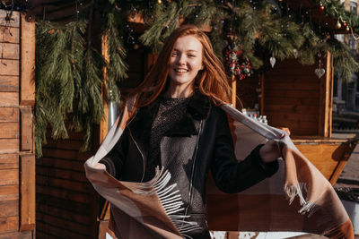 Portrait of smiling young woman standing outdoors