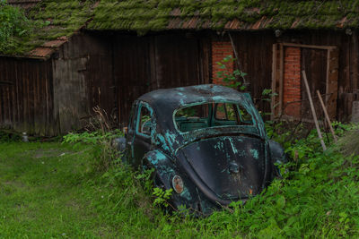 Old abandoned car on field