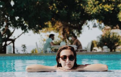 Young woman wearing sunglasses at poolside