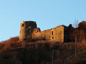 Low angle view of fort against clear blue sky