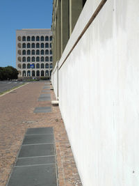 Footpath by building against clear sky