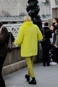 Rear view of women with umbrella walking in city