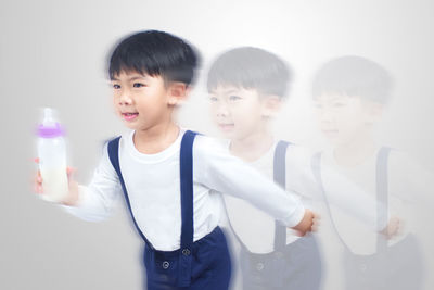 Portrait of a boy standing against the wall