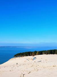 Scenic view of beach against clear blue sky