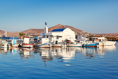 Boats moored in sea against clear sky