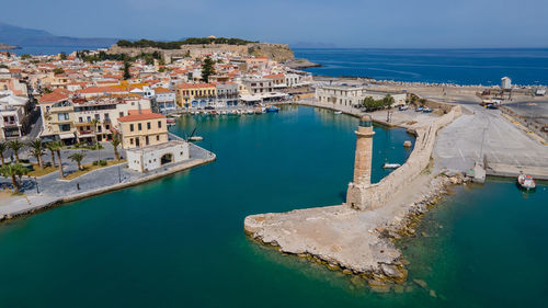 High angle view of buildings by sea against sky