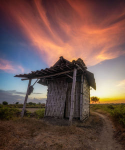 Built structure on field against sky during sunset