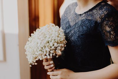 Midsection of woman holding flower bouquet