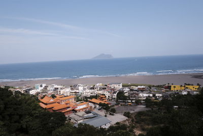 High angle view of townscape by sea against sky